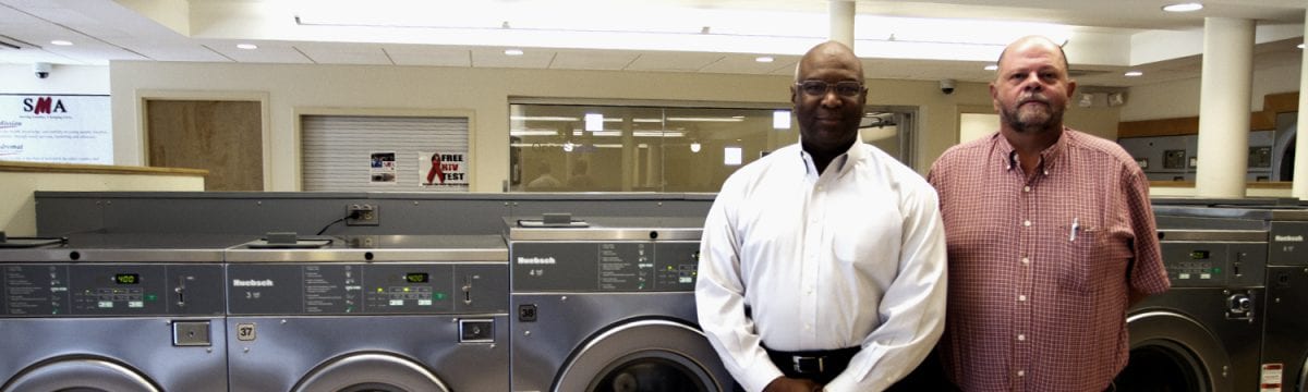 two owners standing in laundromat