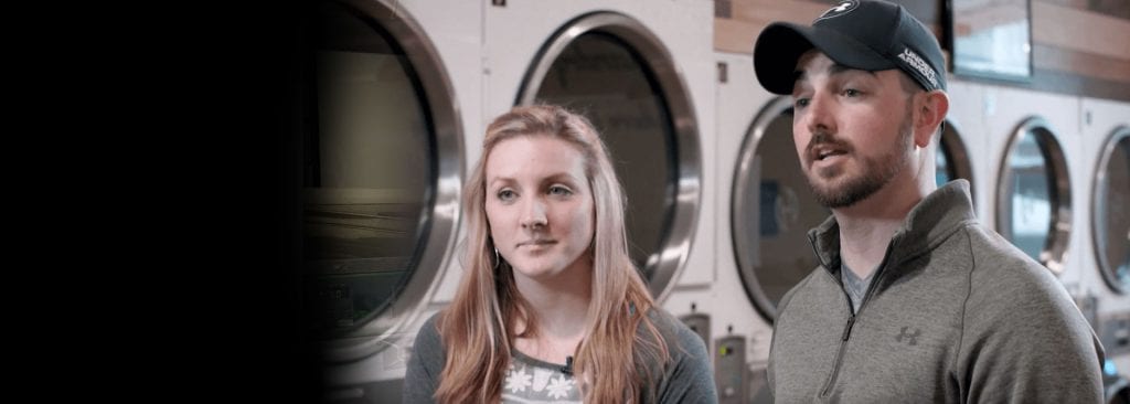 a man and woman in a laundromat