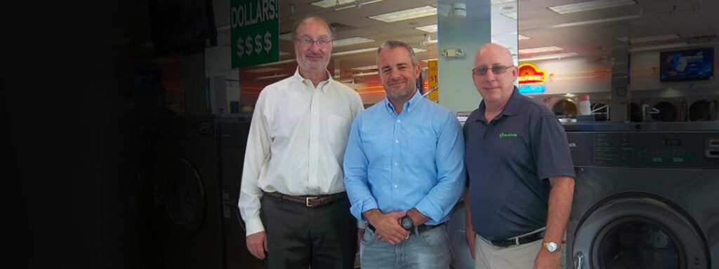 3 men standing in their laundromat