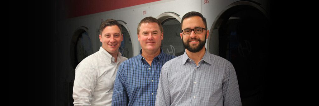 3 men standing in their laundromat