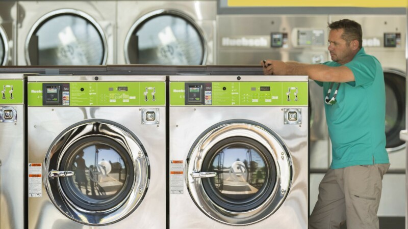 owner stands at washing machine