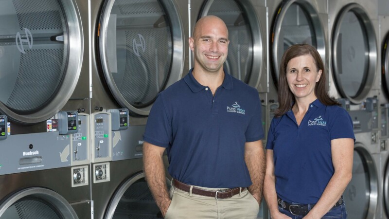 two owners standing in front of machines